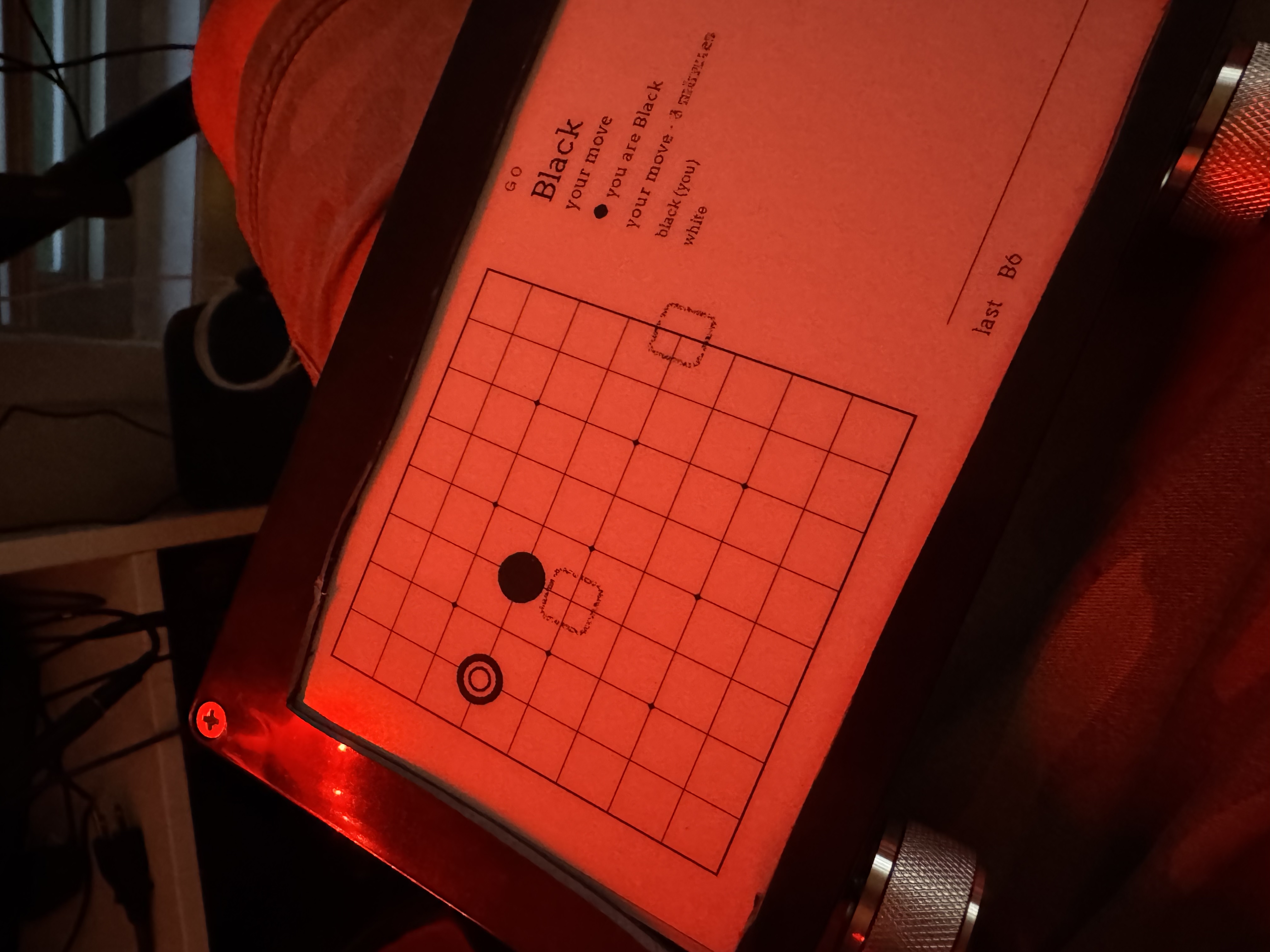 A game of go under the red lamp - the dotted square is the cursor
